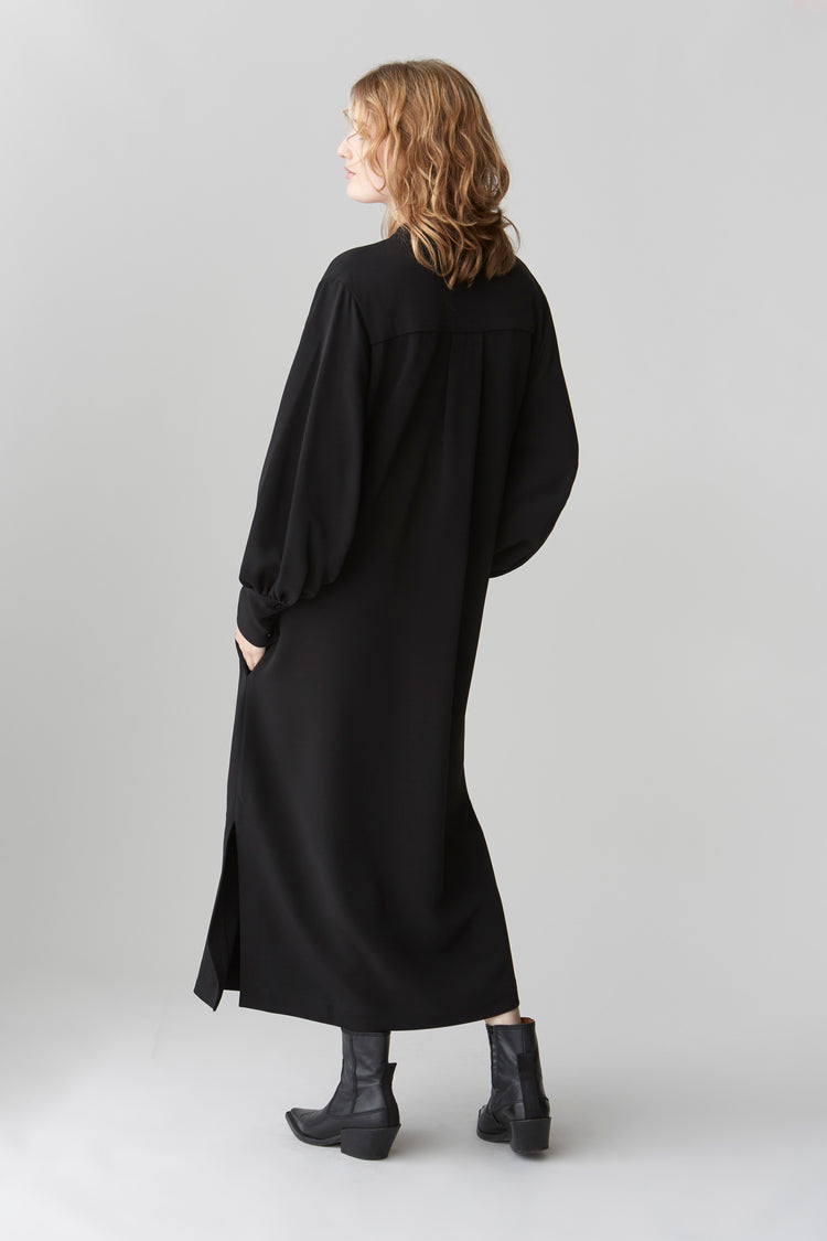 Side profile of JOYCE midi dress showcasing side slits and exaggerated cuffs on blouson sleeves.