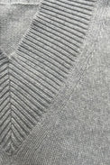Detail of front neckline on a v-neck cashmere sweater in light grey photographed flat.